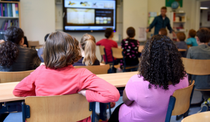 Diverse students in the classroom taking instruction from the teacher